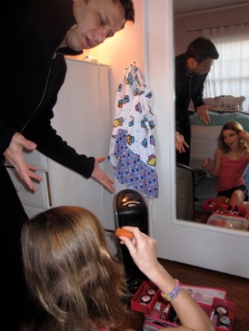 Daughter Applying Makeup In Front Of Space Heater