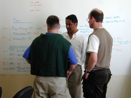 3 people from the business team in front of the white board