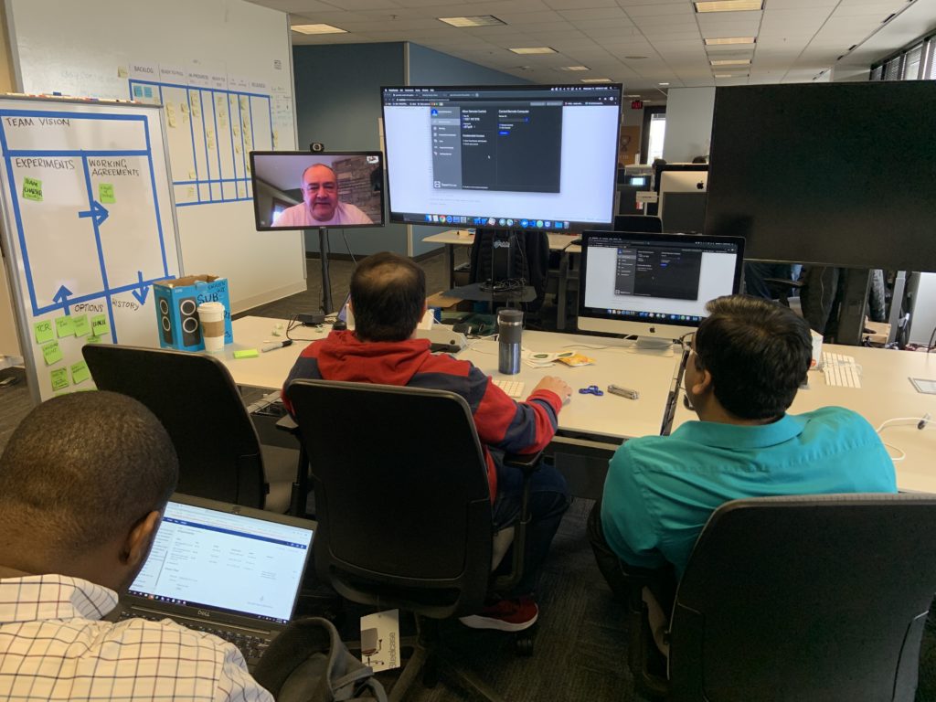 three people sitting in front of three monitors