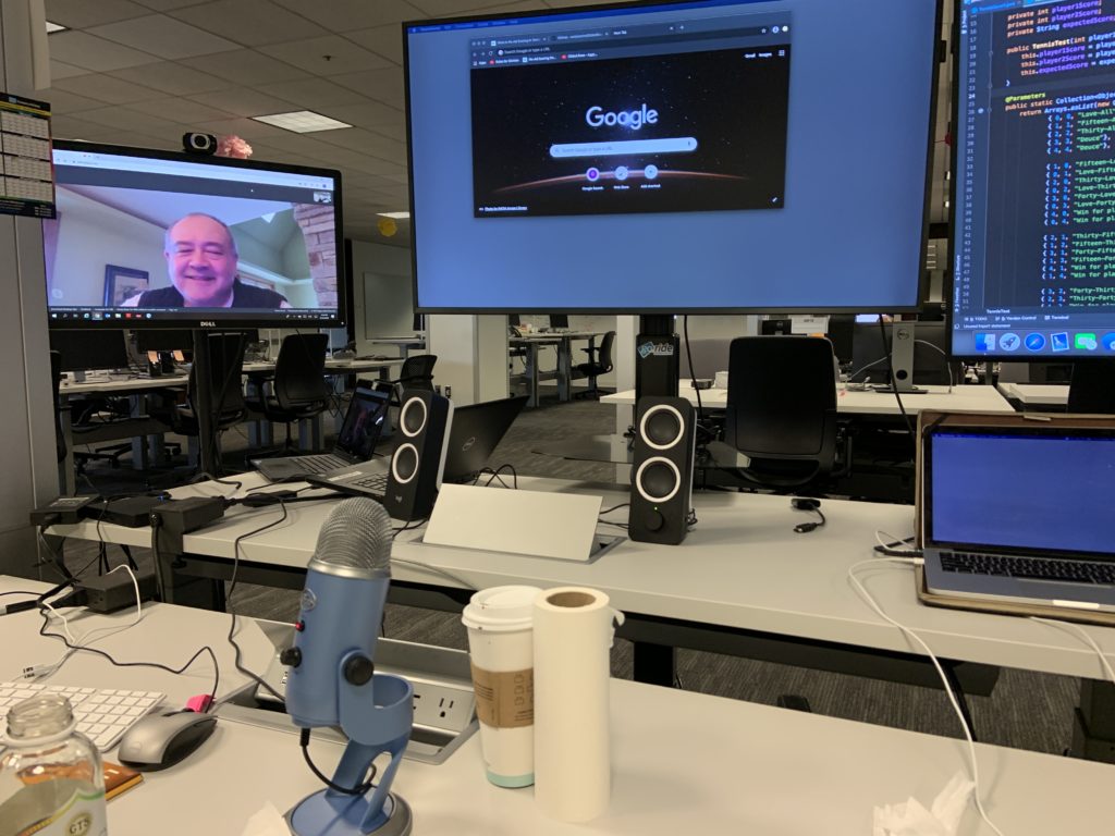 desk with three monitors, microphone, and speakers