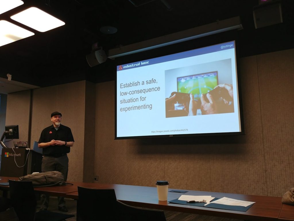 person standing next to video projector screen of text